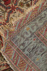 Detail of the fine weave on the reverse of an antique Caucasian rug alongside its tattered edge.