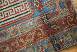 Brilliant ruby red and aqua blue geometric patterns on the distressed pile of an antique Malayer rug.