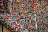 Heavily distressed Guli Hannai design on vintage Persian rug, revealing hand-knotted reverse and fringe.