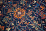 Antique Malayer rug's orange medallion pendant and stylized flora in tone-on-tone navy.