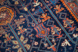 Stylized geometric flora in red, orange, and blue on an antique Malayer rug.