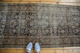 Distressed antique Hamadan runner, highlighting the wide border with faded serrated leaf patterns.
