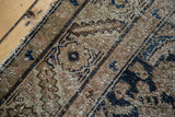 Detailed view of the distressed pile, showing aged brown and dark teal herati pattern.