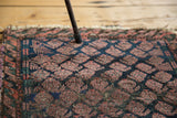 Detail of unusual plum boteh pattern on dark indigo field of the antique Belouch rug.