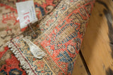 Antique Malayer rug's hand-knotted weave detail showing fringe and muted red, indigo tones.