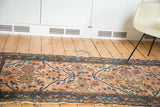 Antique Persian Lilihan rug section showing dusty blush field, splayed floral motifs, and aged side fringe.