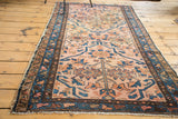 Antique Lilihan rug with blush and gold tones, featuring indigo floral medallions.