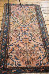 Antique Lilihan rug's blush rose field with rich indigo floral designs and a patterned outer border.