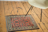 Intricate Herati motif on dusty blush rose red field of a vintage Bibikabad sampler rug.