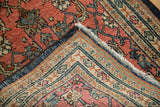 Dusty blush rose Bibikabad rug corner: intricate herati border, white fringe, secured blue edge.