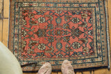 Dusty blush rose red field with herati motif, fine Bibikabad weave, navy border, and fringe.