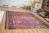 Distressed Lilihan rug, its cherry red field showcasing navy blue and gold floral vines.