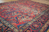 Distressed cherry red field of a vintage Lilihan rug, with navy blue and gold floral sprays.