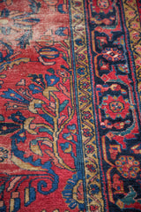 Decorative distress on a vintage Lilihan rug: cherry red field with blue floral vines.