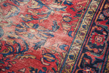 Decorative distressed texture on the cherry red field of a Lilihan rug with navy floral details.