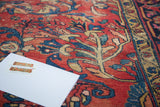 Decorative distressed Lilihan rug with cherry red field, navy blue, and gold floral vines.