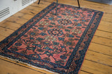 Antique Persian Lilihan rug's intricate repeating floral design on a blush field with teal and bronze.