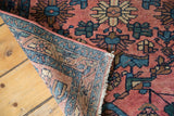 Hand-knotted foundation, fringed end, and blush floral pattern of an antique Lilihan rug.
