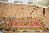 Corner detail of a hand woven Turkish Kilim rug, showcasing blush red and lime green geometrics.