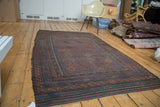 Antique Belouch rug featuring diagonal gul motifs, plant, and wave borders in indigo, bronze, chestnut.
