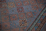 Multi-paneled indigo, bronze, chestnut gul motif and germinating plant border on an antique Belouch rug.