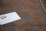 Antique Belouch rug detail showing multi-paneled diagonal gul motifs in indigo and chestnut.