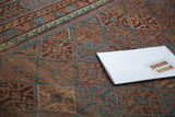 Indigo, bronze, and chestnut multi-paneled gul motifs on an antique Belouch rug.