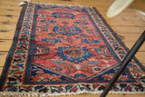 Visible wear and sharp-edged floral design on a distressed antique Persian Dargezine rug.