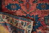 Hand-knotted antique Dargezine rug folded, showing cranberry red field and detailed patterned border.