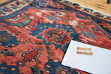 Antique Persian Dargezine rug with distressed cranberry and cobalt sharp-edged floral design.