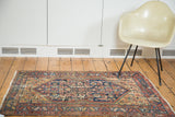 Distressed antique Malayer rug corner, vibrant dandelion yellow, cobalt, and salmon patterns.