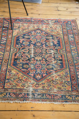 Distressed antique Persian Malayer rug with vibrant blue, yellow, and salmon medallion.