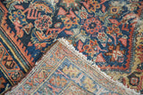 Distressed hand-knotted Malayer rug corner revealing its vibrant cobalt, salmon, and dandelion colors.