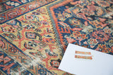Vibrant distressed antique Malayer rug with geometric patterns and abrash in yellow, blue, and red.