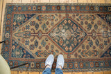 Distressed central diamond medallion and geometric patterns on an antique Hamadan rug.
