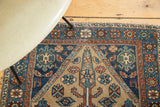 Distressed antique Hamadan rug detail, traditional geometric patterns in softened blues, terra cotta, beige.
