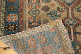 Distressed Hamadan rug showing geometric patterns and glue remnants on its woven reverse.