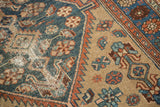 Textured distressed blue field and serrated terra cotta border of an antique Hamadan rug.