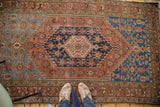 Antique Distressed Malayer rug with faded terracotta, teal, and navy geometric motifs.