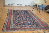Distressed Antique Malayer rug, dark indigo field, repeating herati, playful gem-tone animal motifs.