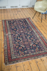 Distressed antique Malayer rug, dark indigo field, gem-tone Herati, animal and floral motifs.