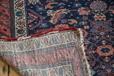 Distressed Antique Malayer rug showing its rich indigo, red, blue herati pile and woven foundation.