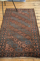 Hand-knotted antique Belouch runner detail, showcasing multi-paneled gul motifs in indigo, bronze, and chestnut hues.