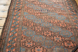 Geometric multi-paneled gul motifs in indigo, bronze, and chestnut on the antique Belouch runner.