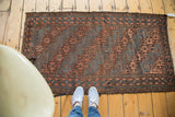 Antique Belouch runner's lower section with indigo, bronze gul motif and decorative border.