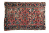 Distressed antique Persian Lilihan rug with charming faded burgundy florals and contrasting navy border.