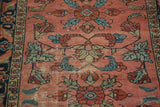 Whimsical floral motifs and distressed texture on the antique Lilihan rug's burgundy field.