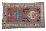 Distressed antique Persian rug fragment, brick red field, double diamond medallions.