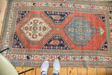 Hand-knotted distressed Northwest Persian rug corner with sky blue medallion and colorful borders.