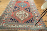Antique Persian rug fragment corner displaying intricate floral borders and time-softened fringe.
